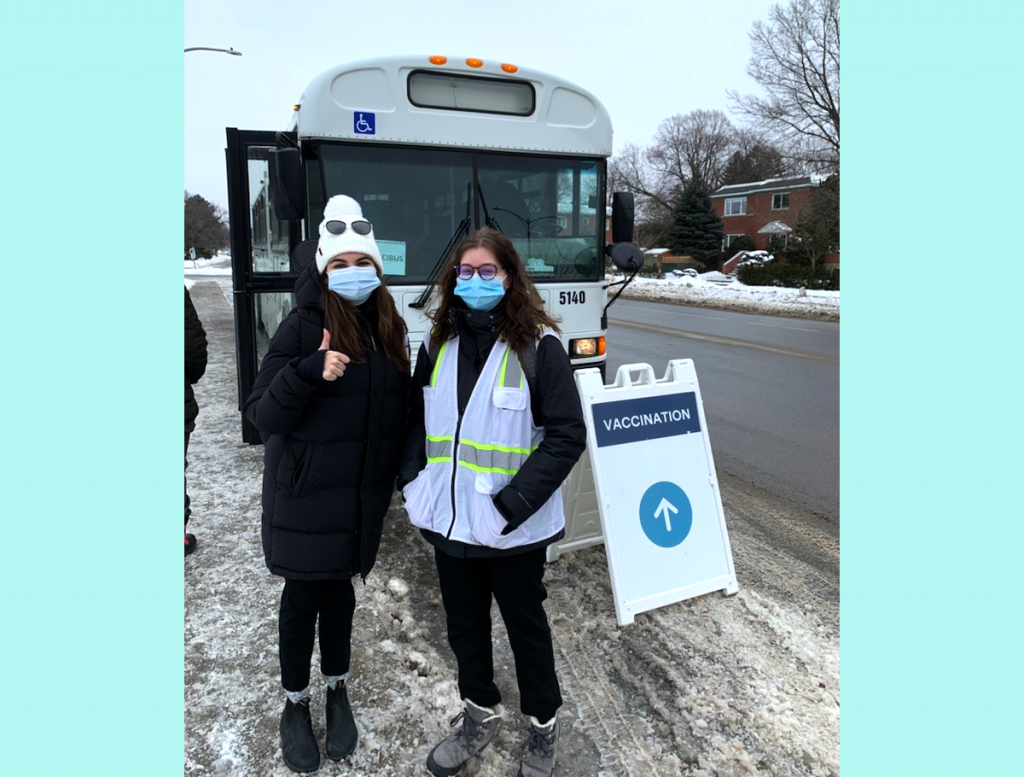 Deux jeunes filles devant le bus de vaccination mobile